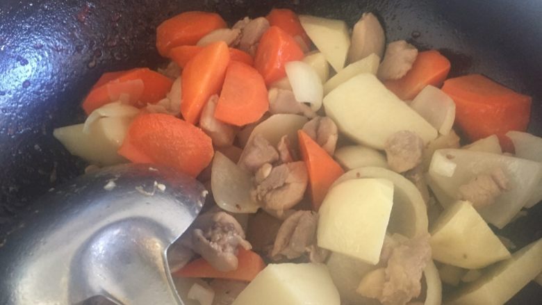 快手咖喱饭,土豆和鸡肉炒出些油时放入切好的洋葱，炒出味道时，放入胡萝卜，一起翻炒