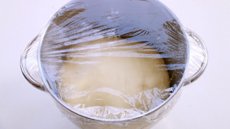 牛奶小面包,盖上保鲜膜放温暖处发酵至两倍大。也可利用烤箱的发酵功能来进行。