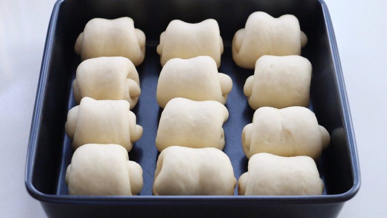 牛奶小面包,依次排列放入烤盘或模具，放入烤箱中二发至两倍大。同时放一碗热水增加湿度。