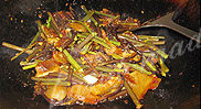 腊肉炒蕨菜,倒入蕨菜，开大火快速翻炒，加入盐调味；