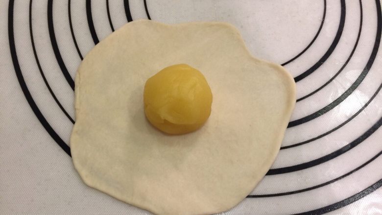 鸡蛋面包,将面团擀成中间厚四周薄的圆片，放入奶油馅，收口捏紧朝下，搓成椭圆形