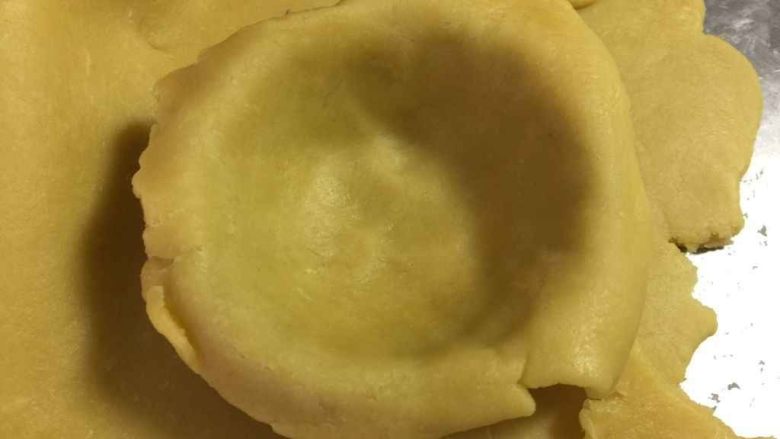 流心芝士挞（最省时无需冷冻配方）,取一个蛋挞模，将面皮放进去，使面皮和蛋挞模贴合在一起，去掉边缘部分。
