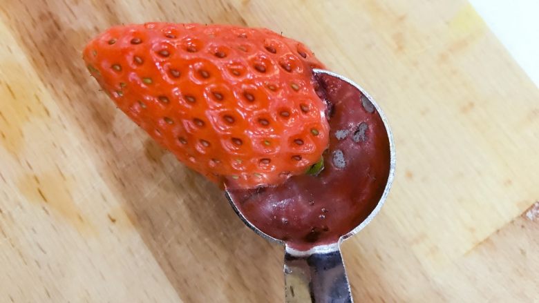 宝宝辅食：草莓苹果小红帽-18M+,拿一个小勺子或圆形水果球挖勺，在草莓靠近叶子那边挖一个圆洞，勺子稍稍大点也没有问题，小芽的水果球挖勺也是大的，稍稍挖浅一点就好，如果挖完发现不够圆，用水果刀简单修一下即可。
》要选择草莓较平整较适合做脸的一面哈。