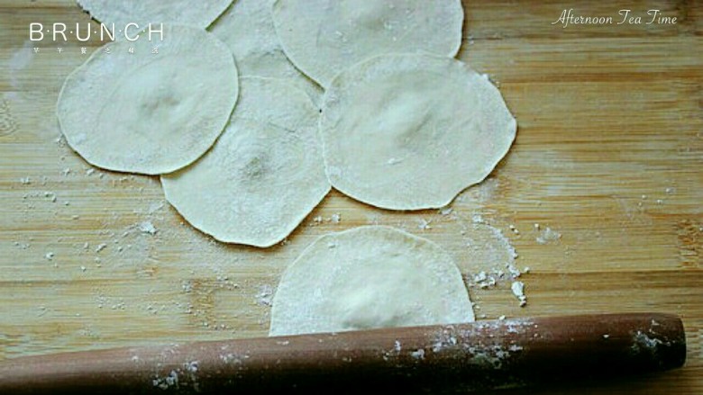 元宝饺子,压面团：洒上面粉，把每个面团用手压扁，再用擀面杖擀成面皮（注意中间厚边薄，防止漏）