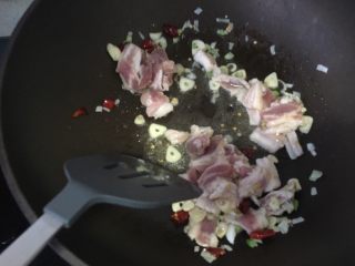 干锅菜花,将五花肉放入锅中，反复翻炒，将葱蒜的味道融合进来。
