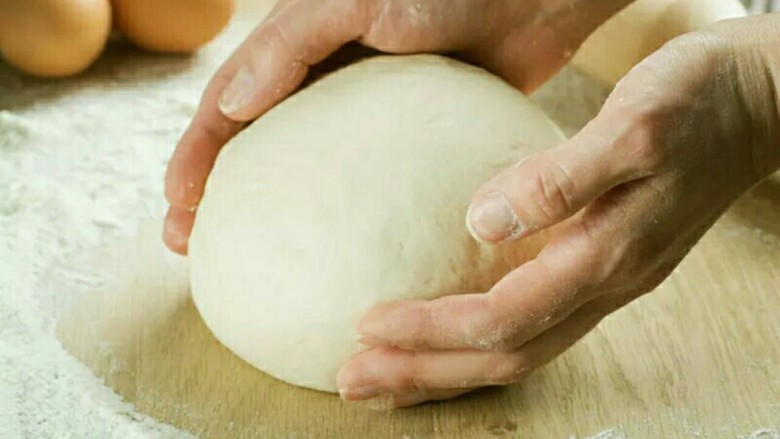 意大利玛格丽特披萨,将搅好的面团取出操作台，使用湿毛巾盖好醒面10分钟。再用面团割刀切200g／一个，用手搓圆。