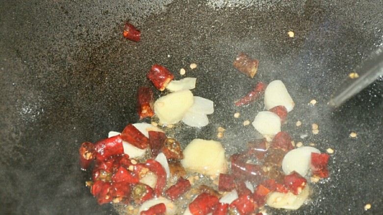 麻辣烫,锅中油热后放入姜、蒜片和辣椒爆香。