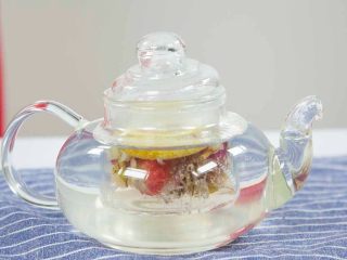 花茶玄饼,将冰糖、花茶、柠檬干用温水泡开
