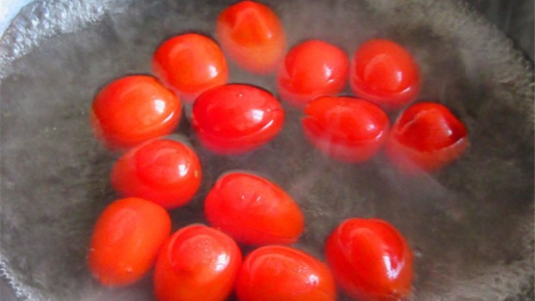 茄汁排骨龙眼肉,在每个小番茄头部划十字，放进开水锅煮烫至皮皱起来捞出