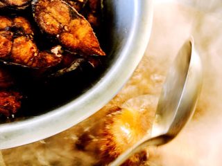 熏鲅鱼#烟台特色#,大火烧开后把炸好的鲅鱼片倒入锅中、加入适量盐和生抽、糖调味