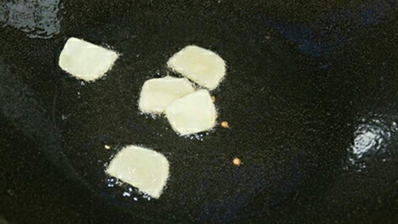 宫保魔芋,锅中油热后放入姜片爆香。