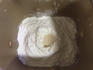 劲脆汉堡包,把牛奶，糖，盐，全蛋液，高筋面粉，酵母，依次放入面包桶里，酵母放在最上面，再用高筋面粉覆盖了