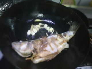 锡纸包烤鲈鱼,就着锅的油放入蒜头、生姜爆香