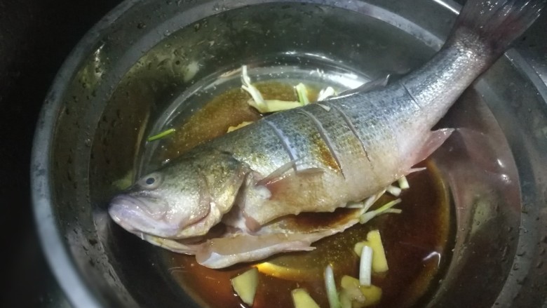 锡纸包烤鲈鱼,加入少许糖、盐把汤汁均匀沾满鱼身腌制15分钟，中间把鱼翻面让鱼均匀的吸收汤汁入味