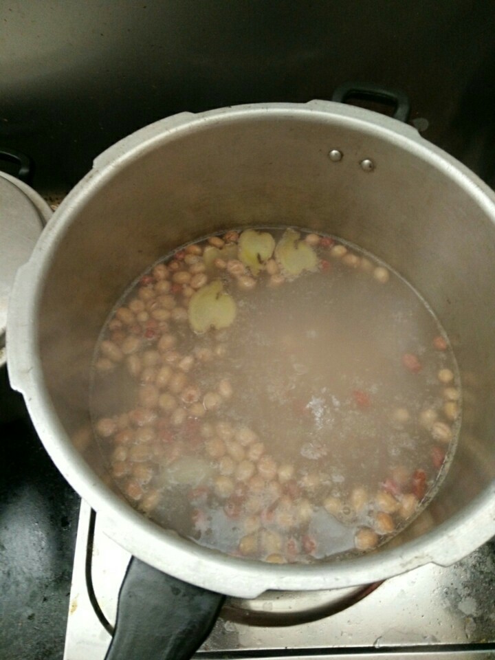 猪尾巴花生木瓜汤,加入花生，盖上盖子中火煲沸5分钟（我用的是高压锅，用沙锅或是其它锅的，水开后要煲15分钟）