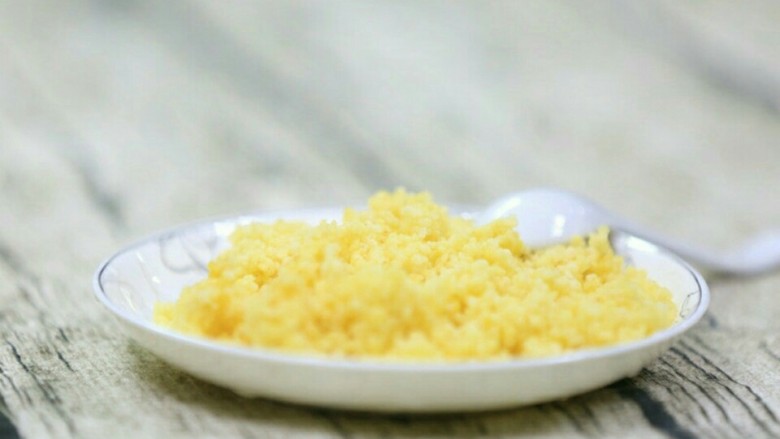 宝宝辅食:蛋黄米糊,小米放入电饭锅蒸熟盛碟子备用。
