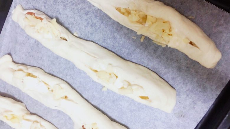 💛卡门培尔奶酪香肠面包💛,将缝口捏紧
用刀在面团上面均匀的剪出2条线的切口
切口里放奶酪
盖上保鲜膜➕湿毛巾。40℃发酵25分钟。
预热烤箱至220℃