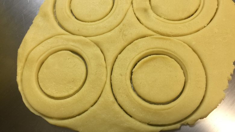 甜甜圈饼干,用甜甜圈模具压出甜甜圈形状，没有模具的可以用瓶子或其他圆形的东西压出甜甜圈形状。