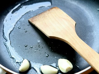 电饭煲版腐竹焖鸭,锅内放蒜爆香。