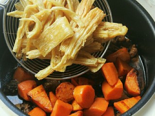 电饭煲版腐竹焖鸭,电饭锅内水沸腾后就可以把胡萝卜，腐竹倒进去，跳键就可以了，如果喜欢鸭肉软烂一点的就再按一次煮饭键。
