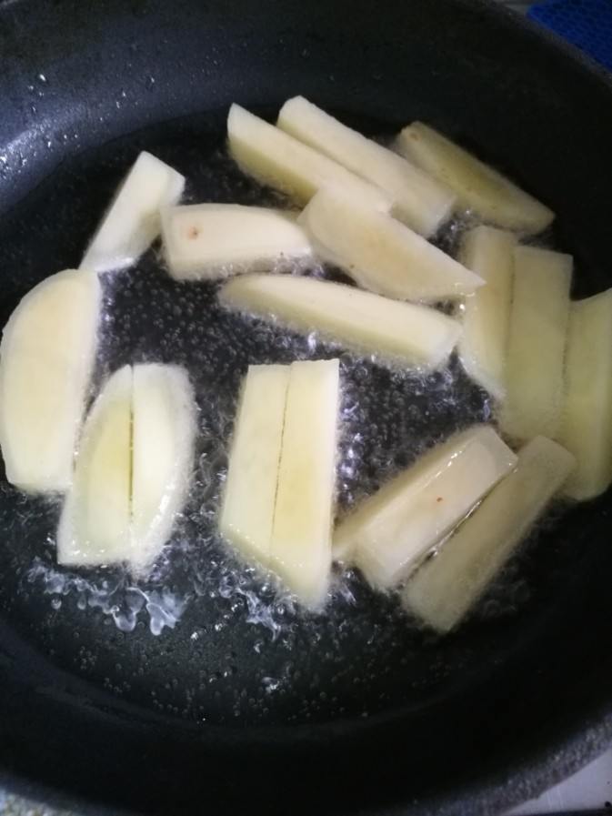 干锅南美对虾,锅里油热后下土豆条炸到微黄捞出。