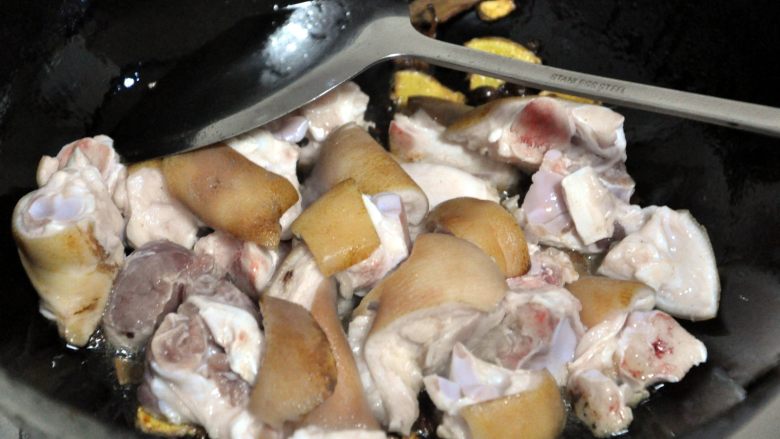 黄豆烧猪蹄,倒入猪蹄，使其翻炒上色。