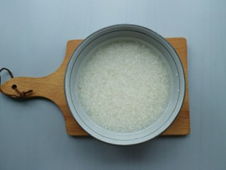 排骨土豆焖饭,将大米淘洗干净后，放入碗里，碗内倒入适量的清水，浸泡20分钟左右