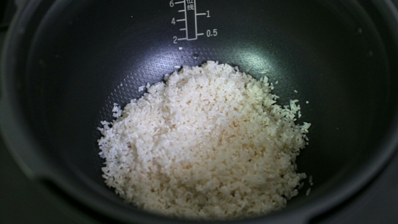 排骨土豆焖饭,将泡好的米倒入锅内。