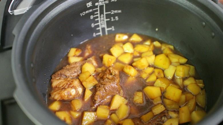 排骨土豆焖饭,将土豆和排骨倒入锅内，然后将排骨土豆的汤汁也一并倒入锅内，汤汁不要全部倒入，加到水位线3的位置即可。
