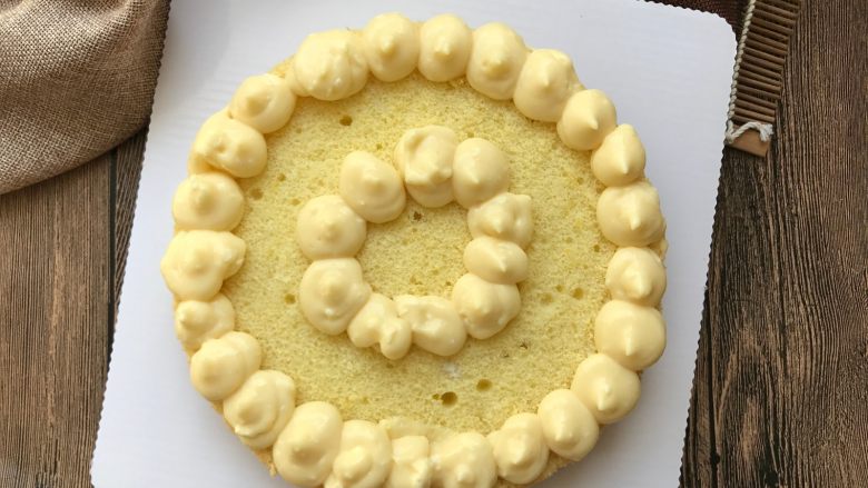 豆乳水果蛋糕,取一片蛋糕片，如图裱上两圈豆乳。