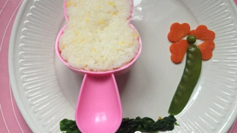 宝宝创意餐--穿花裙子的兔兔,用水煮蔬菜摆好花造型，饭用模具压实。