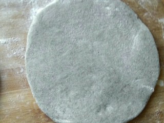 黑芝麻糖饼,发酵成功后，擀成圆饼放入白糖馅，用擀面杖在擀成圆，
