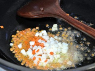 褐麦香肠烧麦,热锅倒入玉米油 ，油热倒入胡萝卜和山药，快速翻炒几下。