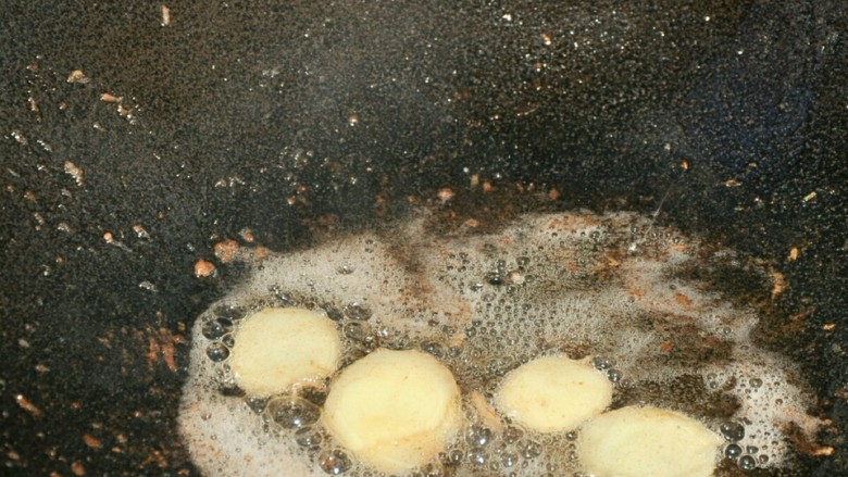 干锅茶树菇,姜片放入油锅中爆香。