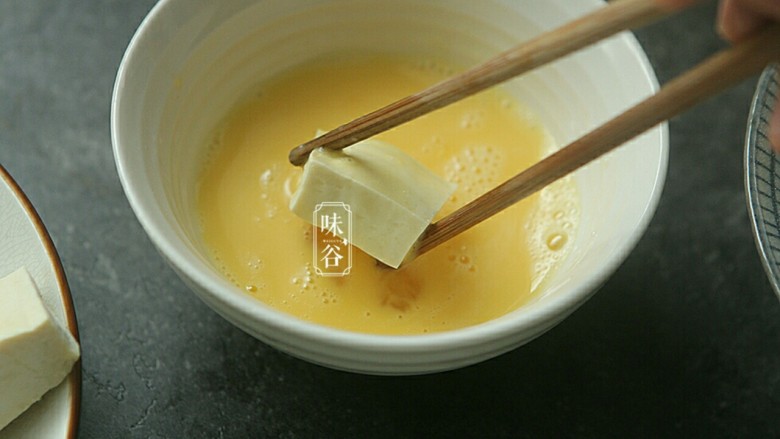 蚝油一口豆腐,先把豆腐在蛋液种浸一下 。