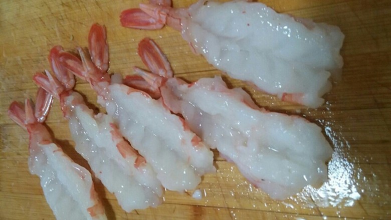 原汁凤尾虾,用刀在虾背剖开，并刀拍平