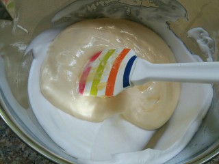 萌萌哒——小黄鸭酸奶戚风蛋糕,把翻拌好的面糊倒入蛋白中用同样的手法混合均匀