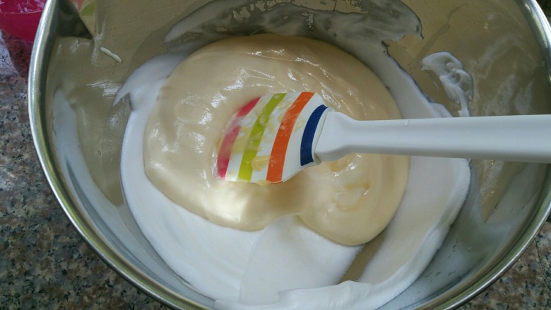萌萌哒——小黄鸭酸奶戚风蛋糕,把翻拌好的面糊倒入蛋白中用同样的手法混合均匀