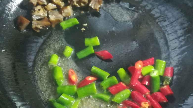 辣椒炒腊鸭,把鸭块扒在一边，下青红尖椒段大火炒半分钟。