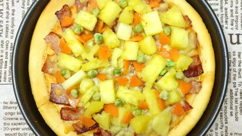 培根菠萝味披萨🍕,在披萨饼上均匀摆放菠萝切片，胡萝卜碎和青豆