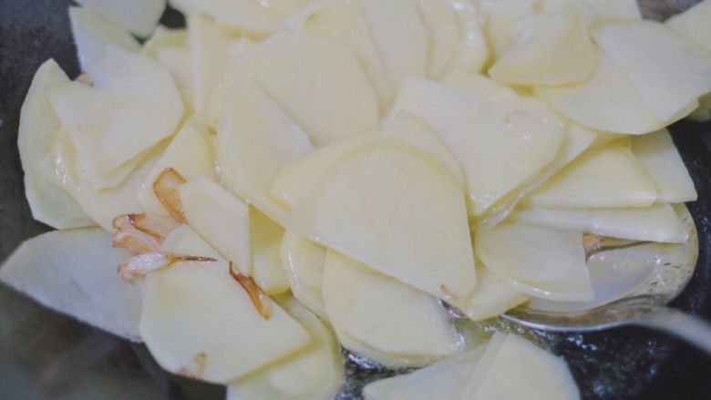 青椒香肠土豆片,葱头和蒜片出香味儿后倒入土豆，翻炒翻炒～