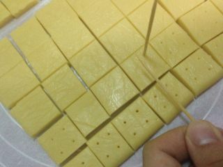 奶油奶酪小方,放入冰箱半小时后取出切小块，用牙签在方块上戳洞方便烤熟