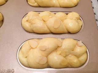 辫子面包（中种）,发酵好的面包刷上蛋黄，放上几片杏仁片装饰