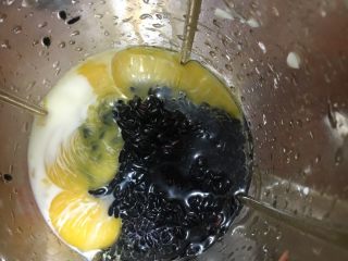 黑米蒸蛋糕,捞出沥干水分，和玉米油、牛奶、蛋黄一起放入搅拌机打匀