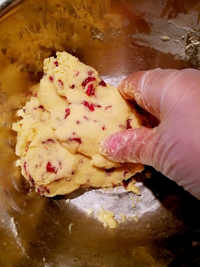 低糖蔓越莓饼干,大概捏压后成型了，不要捏太多，手温度高，把手套拍拍面粉团，手套上的面粉就会粘到面粉团上
