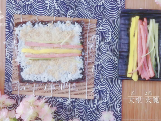 樱花寿司-踏青赏春最佳美食伴侣,在中间位置摆放1条大根、2根火腿条、2根黄瓜条