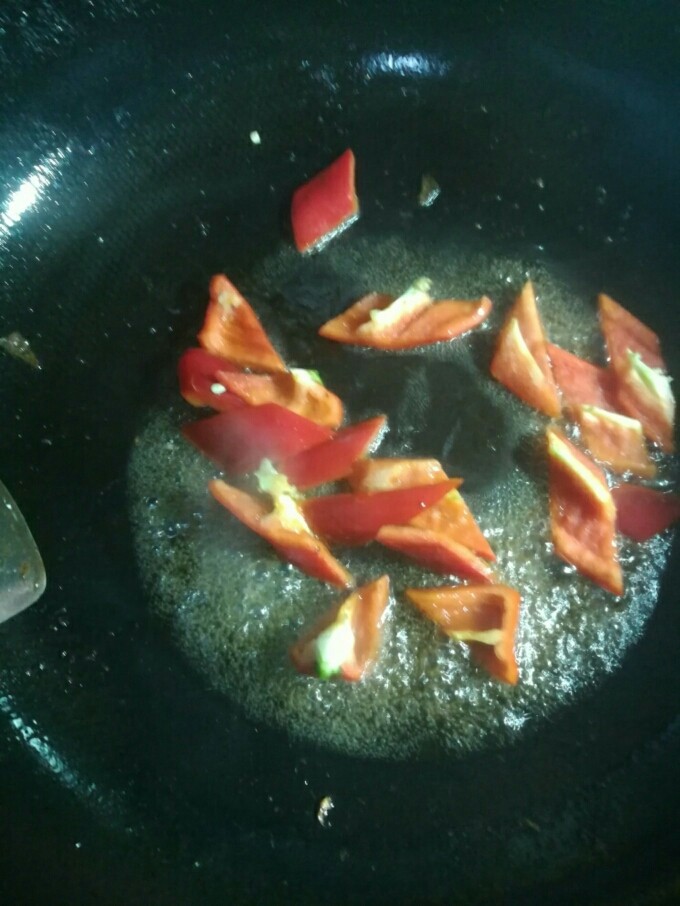 荷兰豆炒腊肉,先下红彩椒块中火炒十秒左右。