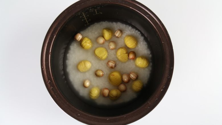 排骨板栗香焖饭,将洗好的大米放入电饭锅，加入适量的水，放入洗干净后的板栗、莲子。
