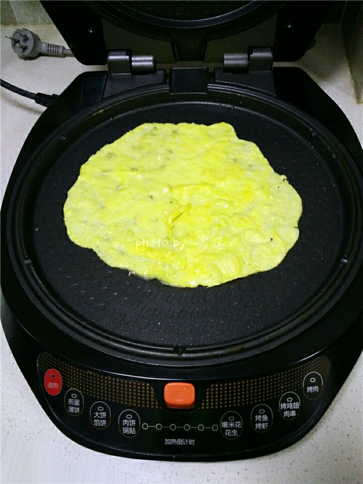 西红柿鸡蛋披萨,电饼铛刷油，倒入蛋液；只打开电饼铛的下开关，启动预热程序； 