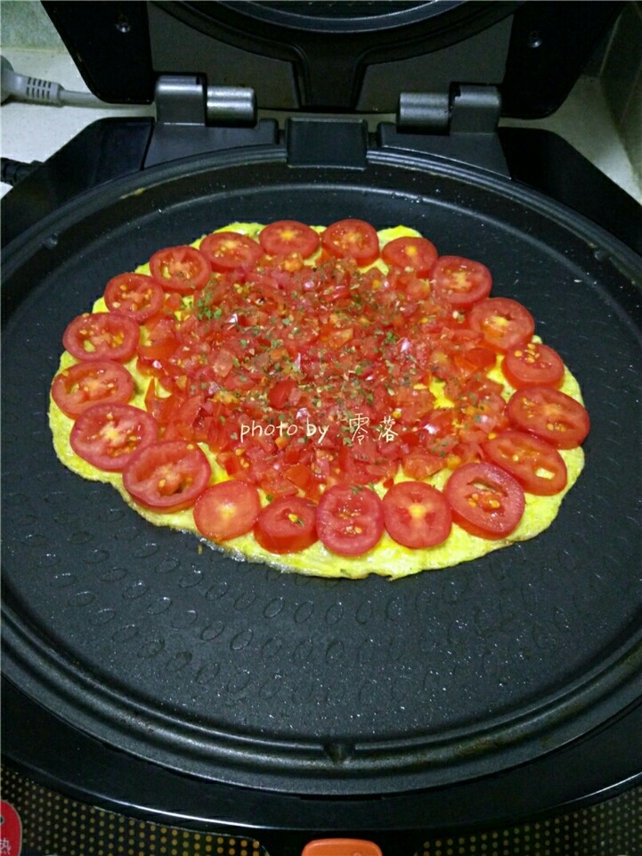 西红柿鸡蛋披萨,再撒入适量盐，牛至叶，<a style='color:red;display:inline-block;' href='/shicai/ 3001'>罗勒</a>，欧芹；